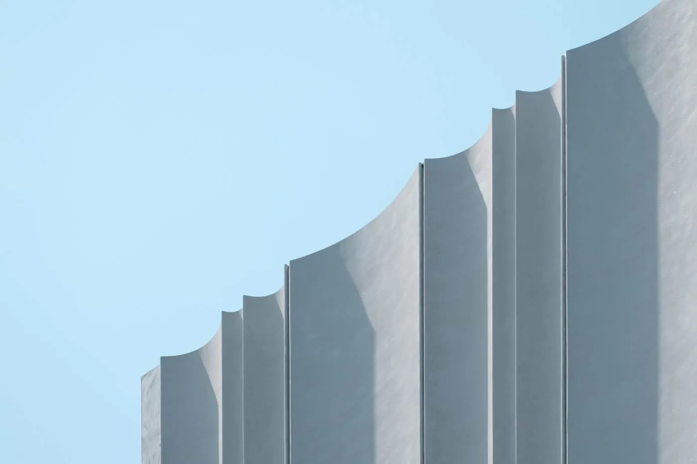 Concrete architectural fins rising against a pale sky